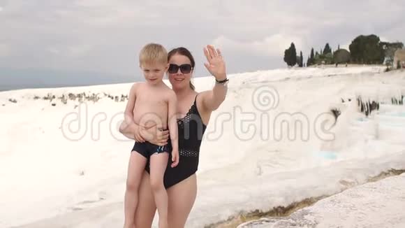 小男孩和他的母亲在帕穆凯尔的石灰华游泳池里玩水视频的预览图