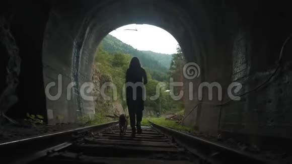 隧道里一个女孩的剪影一个带狗的女孩坐火车去从隧道里出来视频的预览图