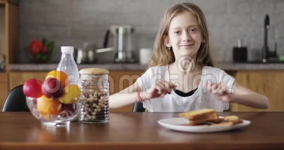 漂亮的女学生长发坐在厨房的桌子旁视频的预览图