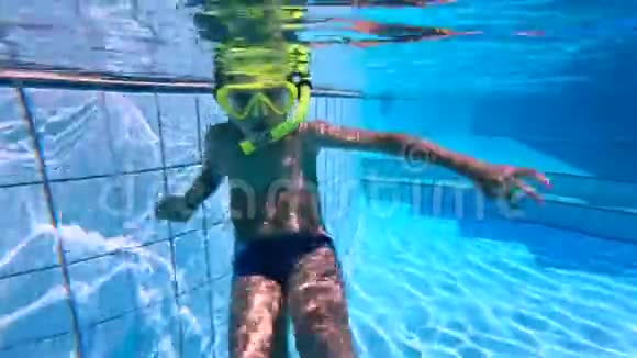 一个男孩戴着潜水面具漂浮在游泳池里视频的预览图