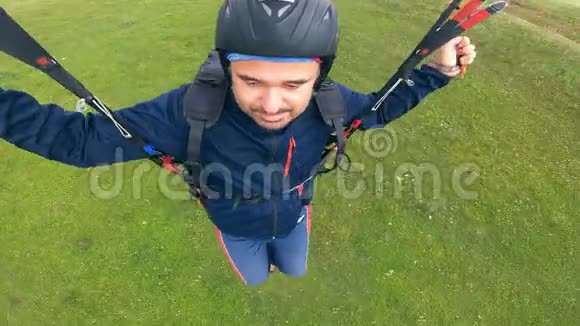 戴着头盔的人在操纵滑翔伞滑翔伞飞行视频的预览图
