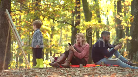浪漫和爱情落叶愉快的家庭野餐父母和儿子在户外玩得很开心快乐视频的预览图