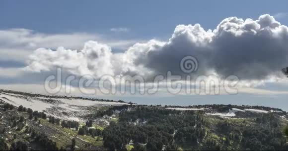 山顶后面云景的时间流逝雪岩石悬崖和深蓝色的天空高空视频的预览图