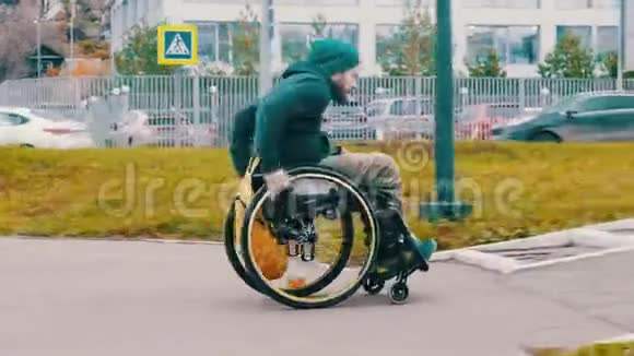 坐在轮椅上的残疾人成功地试图把轮椅从街道上的坡道上驾驶视频的预览图