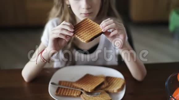 一个漂亮的女学生吃白面包吐司的肖像视频的预览图