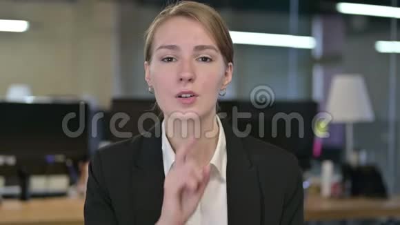 年轻女商人把手指放在嘴唇上的肖像视频的预览图