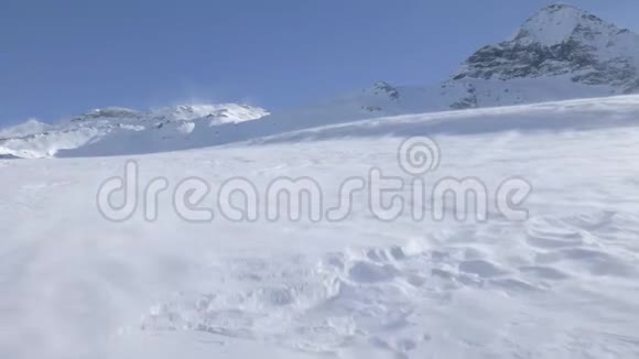 在阿尔卑斯山被风吹拂的地面上飘来的雪视频的预览图