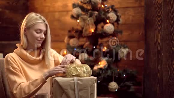 金发女人把圣诞礼物包装成纸快乐的女人打开圣诞礼物设计礼品盒手工制作交货视频的预览图