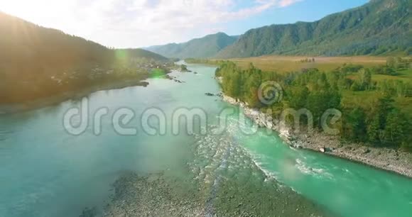 在阳光明媚的夏季早晨低空飞行在带岩石的新鲜快山河上视频的预览图