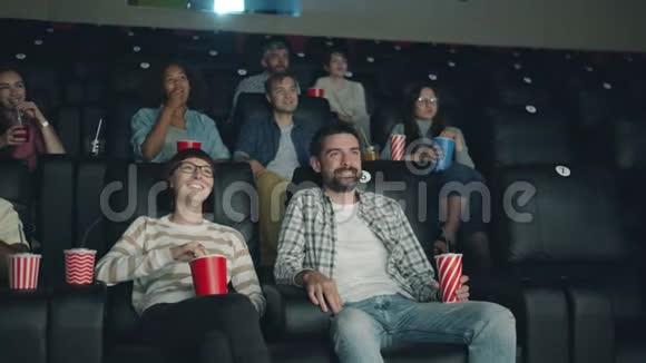 快乐的年轻人在电影院看喜剧笑着看屏幕视频的预览图