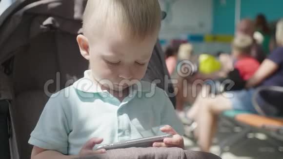 小男孩从智能手机看视频孩子们玩智能手机休闲儿童技术互联网视频的预览图