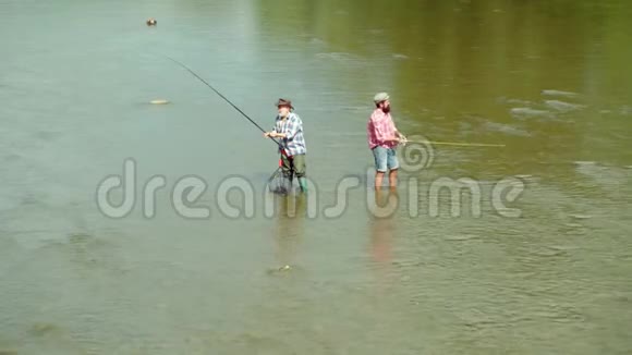 父亲和儿子在兴褐鳟鱼父子俩一起放松几代人的男人有人钓鱼男子捕鱼视频的预览图