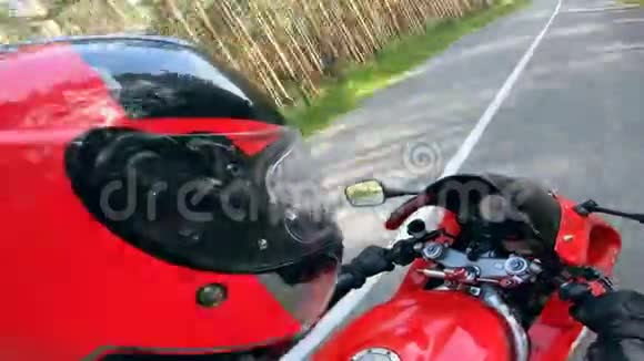 一个骑自行车的人骑着一辆红色摩托车在路上戴着头盔视频的预览图