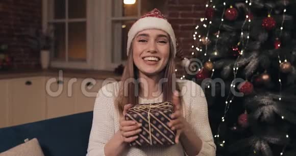 活泼的社交微笑迷人的年轻女人坐在圣诞节的家背景一个爱聊天的女孩视频的预览图