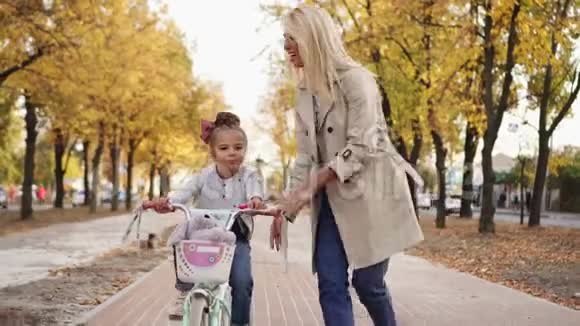 小女孩在公园散步时拥抱和亲吻妈妈视频的预览图