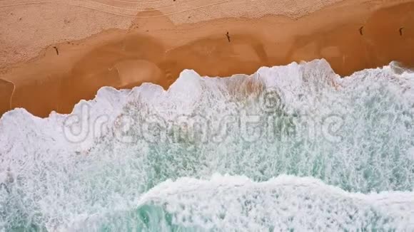高空俯视海浪向美丽的沙滩滚动4k鸟翠绿色海洋的眼睛镜头视频的预览图
