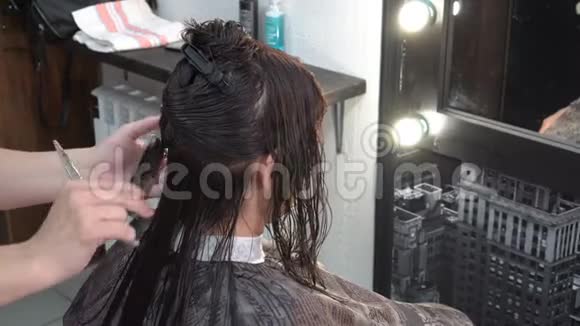 理发师理发师做剪发女孩谁坐在镜子前在沙龙美容快关门后景4K视频的预览图