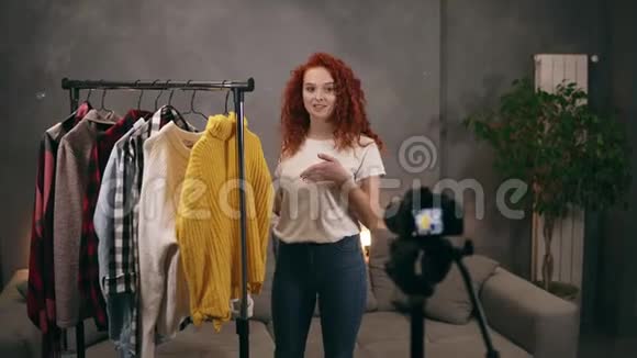 女造型师录制视频为在线博客显示时髦的衣服交谈和手势使用相机女孩尝试视频的预览图