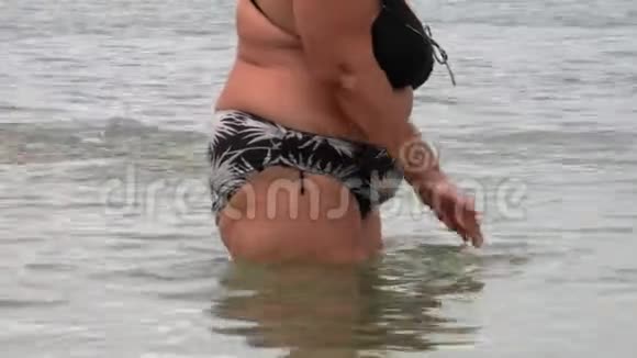 超重的成熟女人在海上穿着泳装她的身体视频的预览图