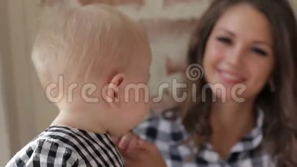 一幅幸福的年轻母亲的肖像带着一个婴儿看着相机视频的预览图
