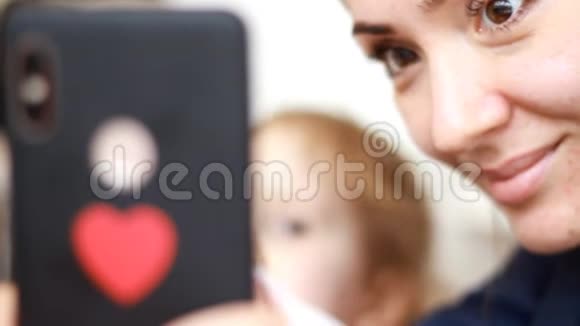 一个女人和她的孩子用手机的特写肖像视频的预览图