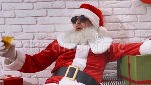 太阳眼镜上的圣诞老人享受着起泡葡萄酒视频的预览图