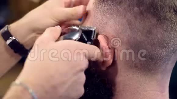 用专用毛刷将头发用电动剃须刀在男性头部近耳处用后视特写拍摄视频的预览图