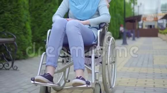 年轻的穆斯林残疾人戴着传统的轮椅围巾与街上一位穆斯林朋友亲密沟通视频的预览图