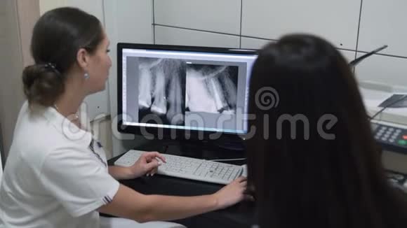 牙科医生在屏幕上给病人看下颚的X线照片动作缓慢视频的预览图