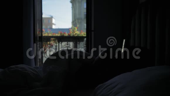 一个女孩在阳光明媚的夏日靠窗睡觉的剪影视频的预览图