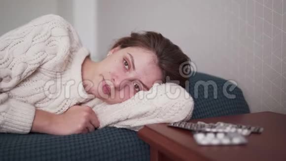 躺在床上的女性肖像爱玲白种人请病假的女性躺在卧室的床上的白色毛衣里流感视频的预览图