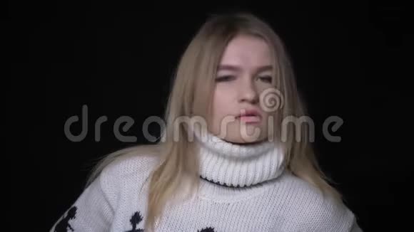 年轻漂亮的白种人女青年的特写镜头穿着毛衣自信地看着背景镜头视频的预览图