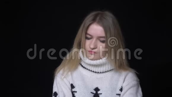 穿着毛衣的年轻漂亮白种人女性的特写镜头她挥舞着头说不要看背景镜头视频的预览图