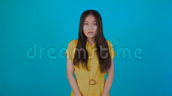 惊讶震惊兴奋的亚洲女人的脸孤立在蓝色的背景上夏天穿t恤的年轻亚洲女孩复制空间视频的预览图