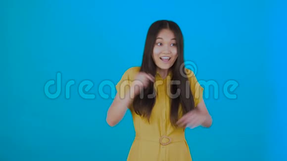 我有个主意亚洲女孩想出了一个好主意很高兴跳舞孤立在蓝色背景上视频的预览图
