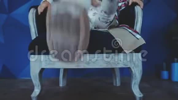 一位戴着帽子坐在白色椅子上的漂亮时髦女孩视频的预览图