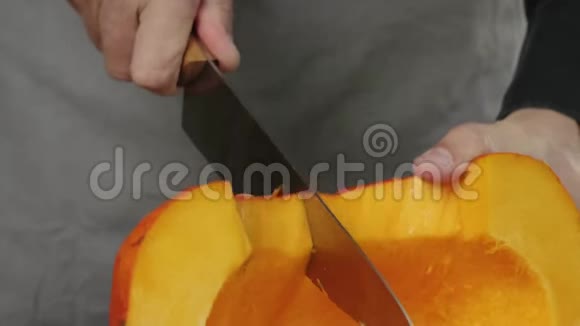 奶油南瓜汤烹饪健康食品厨师把一个新鲜的橙色南瓜切成两半放在木桌上快关门4K视频的预览图