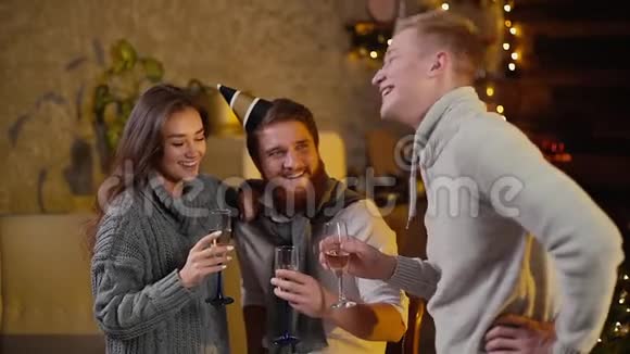年轻男子与夫妇在庆祝新年聚会时碰着香槟酒杯视频的预览图