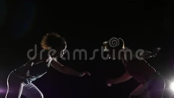 运动女性在黑暗中练习卡普伊拉对抗聚光灯特写慢动作视频的预览图
