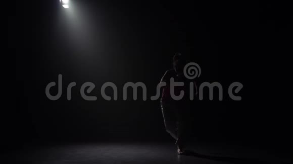 慢动作女性练习卡波伊拉在黑暗中聚光灯下在演播室视频的预览图
