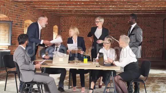 八位商界人士穿着办公套装一起集思广益视频的预览图