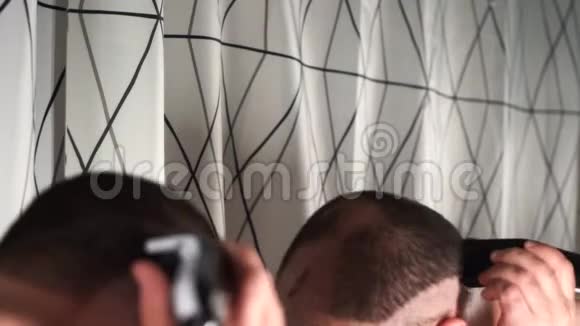 浴室里的帅哥用电动剃须刀剃头视频的预览图