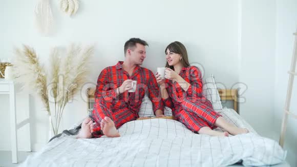 年轻的幸福夫妇在床上吃早餐视频的预览图