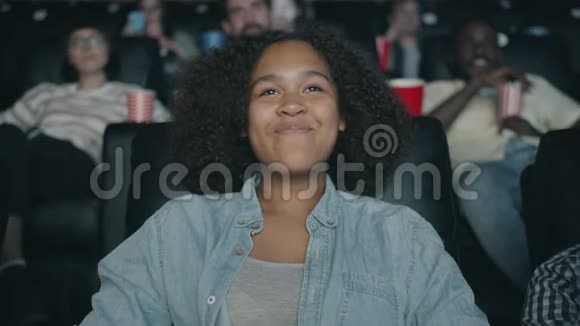 快乐的非裔美国少年在电影院里笑看电影的肖像视频的预览图