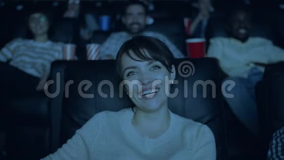在黑暗的电影院里美丽的女士笑着看有趣的电影视频的预览图