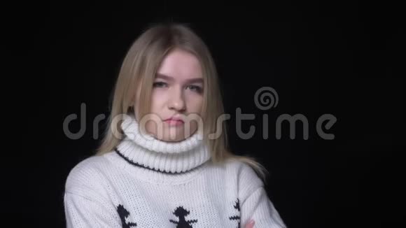 穿着毛衣的年轻漂亮白种人女性的特写镜头点头称是看着背景隔离的相机视频的预览图