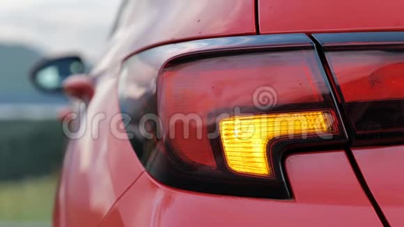 在白天发生道路事故后在背景模糊的情况下在汽车上闪烁后方危险警告灯视频的预览图
