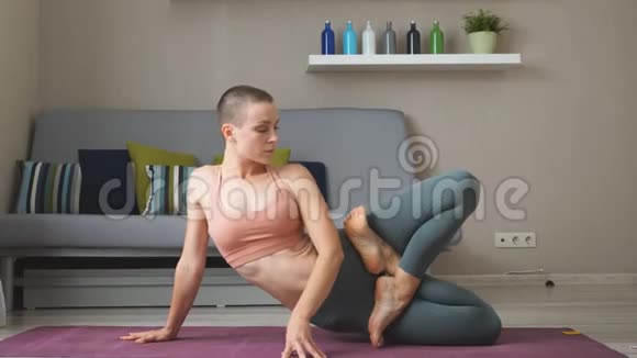 年轻健康的白种人女人在白色的大房间里的垫子上练习瑜伽视频的预览图