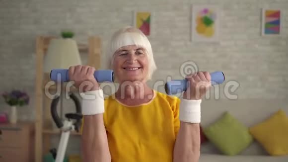 积极运动健身奶奶在客厅里用哑铃充电视频的预览图