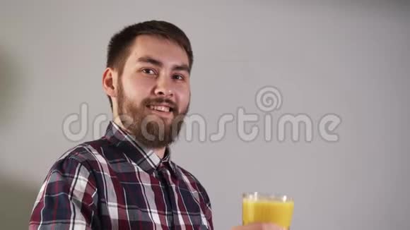 男人举起一杯橙汁特写镜头微笑着看着镜头视频的预览图